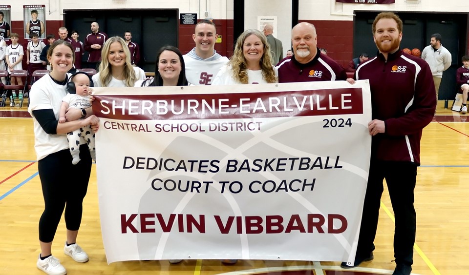Coach Vibbard and family with banner (2/2024)